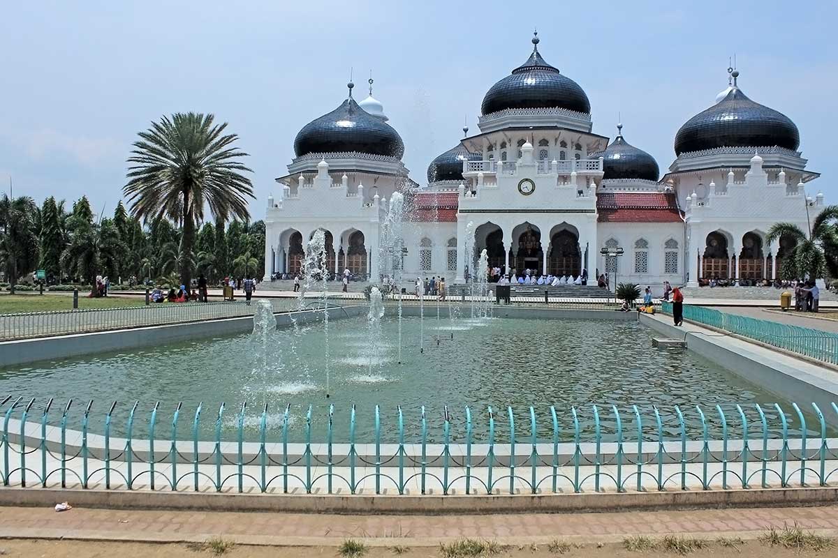 An ornate Indonesian mosque by a water pool