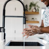 Man_washing_hands_at_kitchen_sink_stock_image_from_Canva