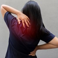 Woman_in_pain_massaging_shoulder_stock_image_from_Canva