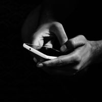 grey scale photo of person holding smartphone from pexels