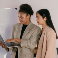 two people looking at laptop stock image by mikhail nilov from pexels