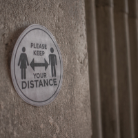 COVID keep your distance sign on wall_sourced via Canva