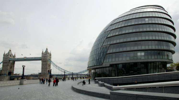 A large modern building beside a bridge | London city hall