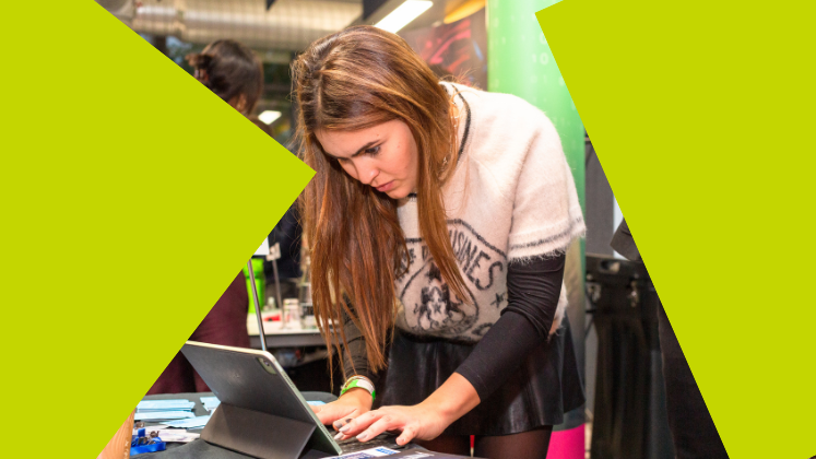 A student types on a laptop at a careers fair