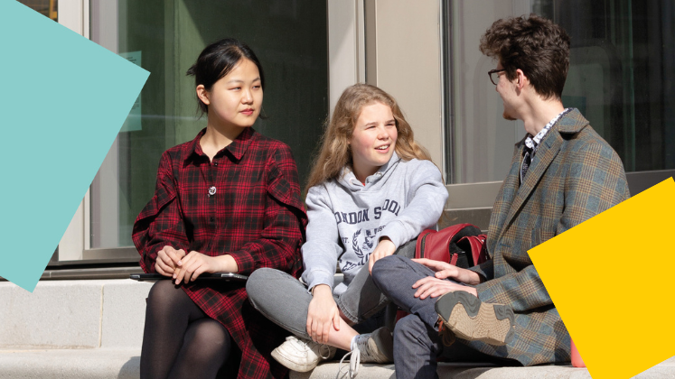 Three students sat outside having a conversation