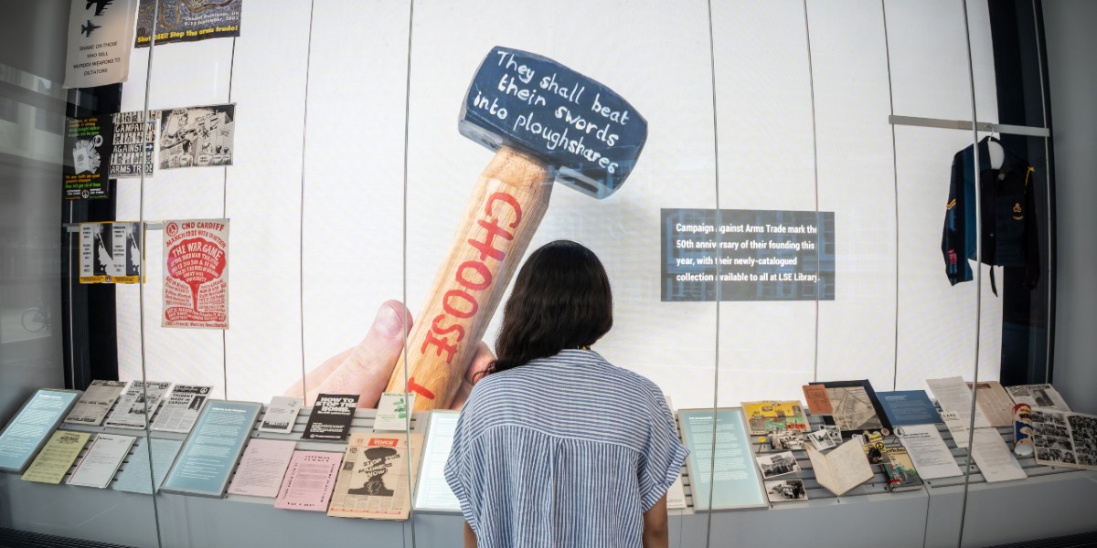 A person stood in LSE Library Gallery looking at exhibits