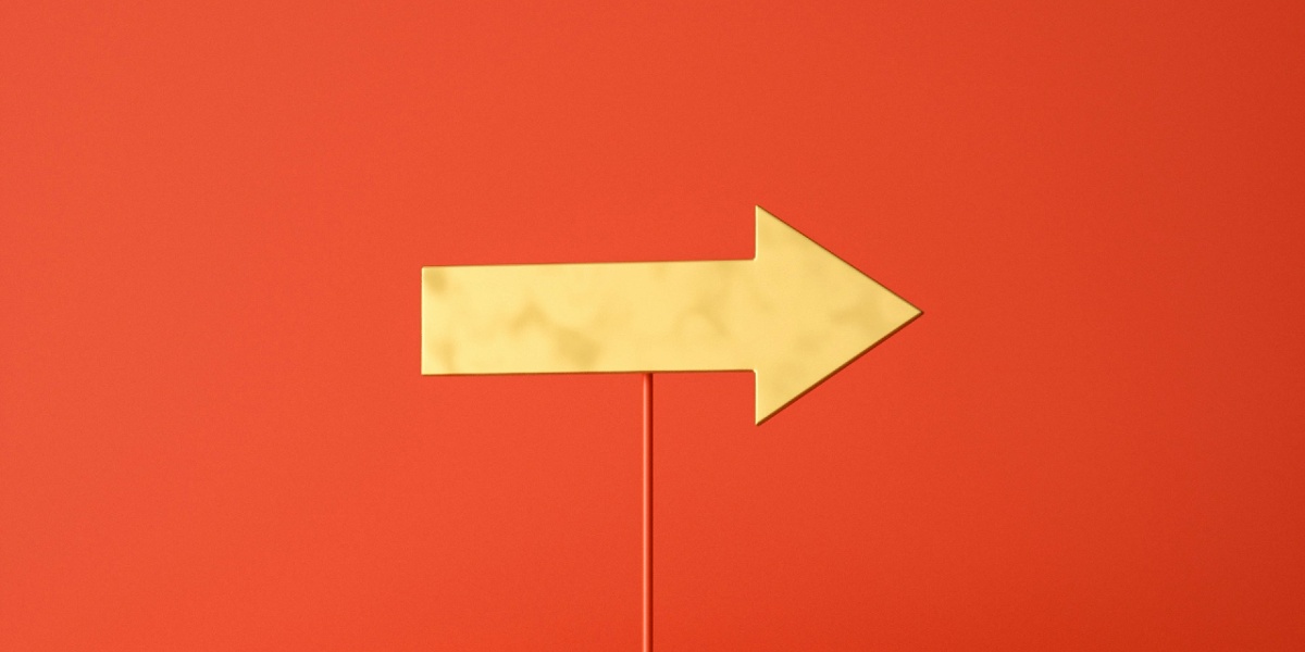 A yellow arrow pointing and set against a red background