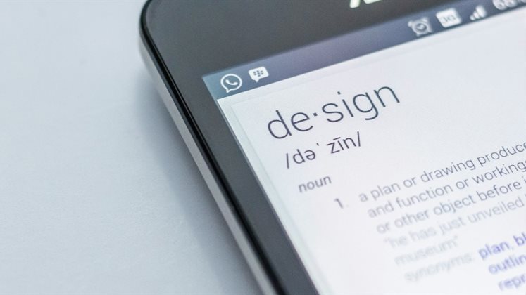 A phone with the word 'Design' on the screen above a definition