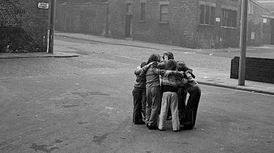 A group of children huddled together in a street