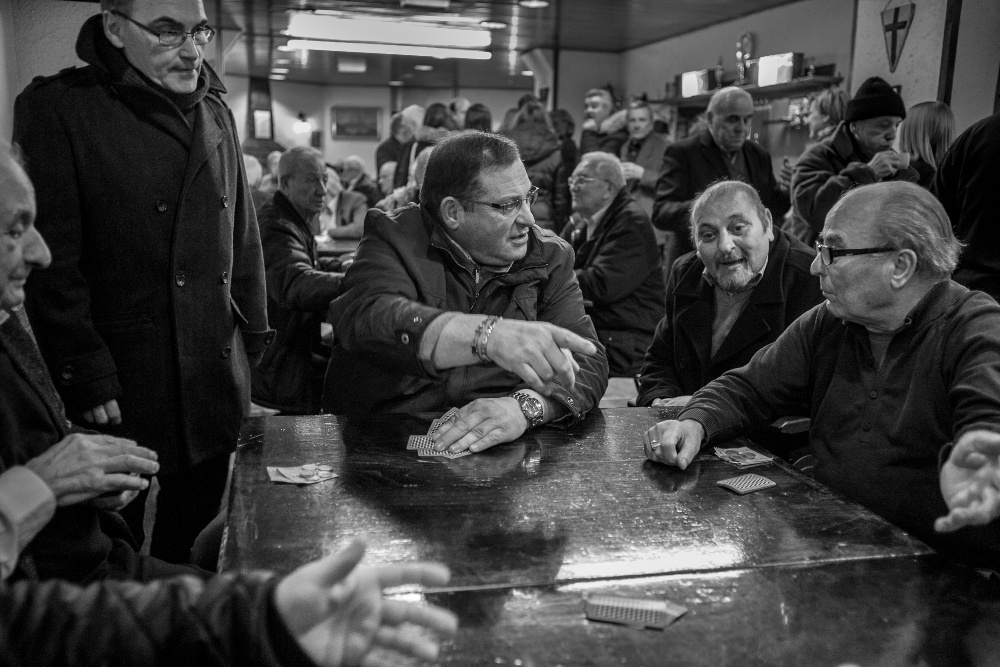 A group of men sat around a table playing games together and talking