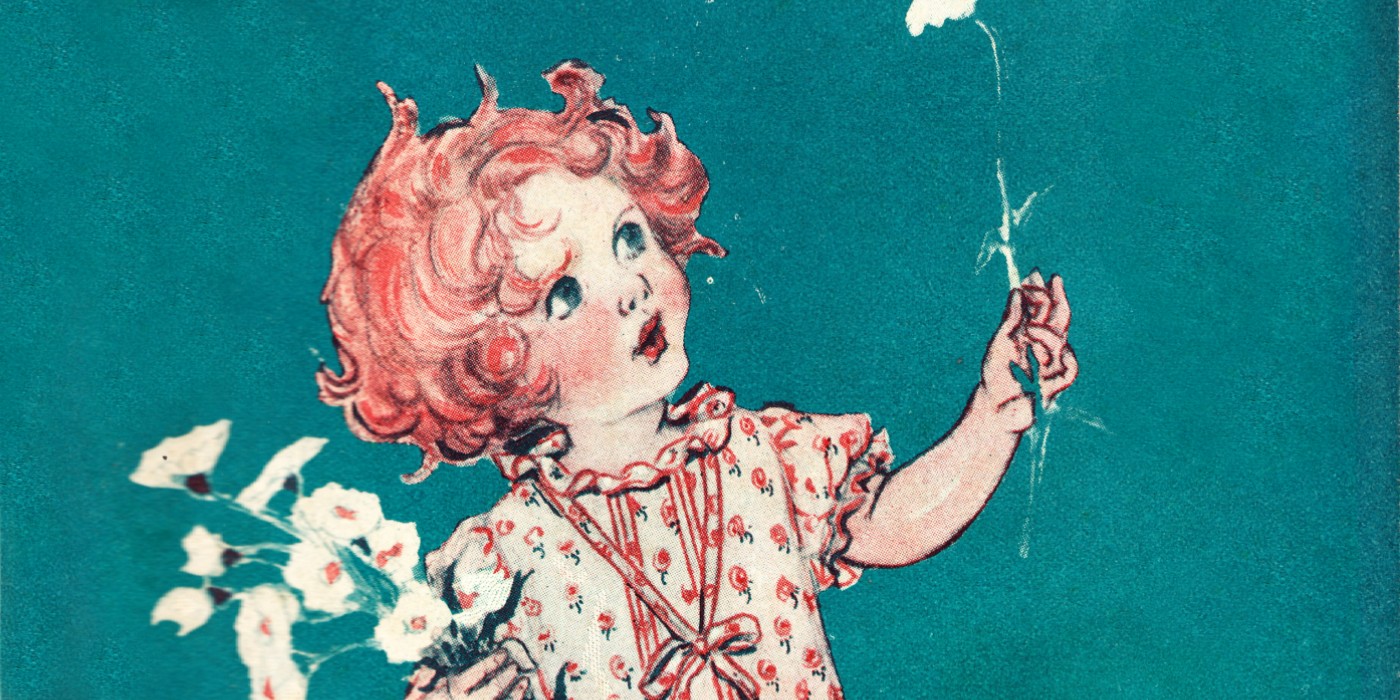 A red-headed girl wearing a dress looking upwards toward a flower she is holding in her hand