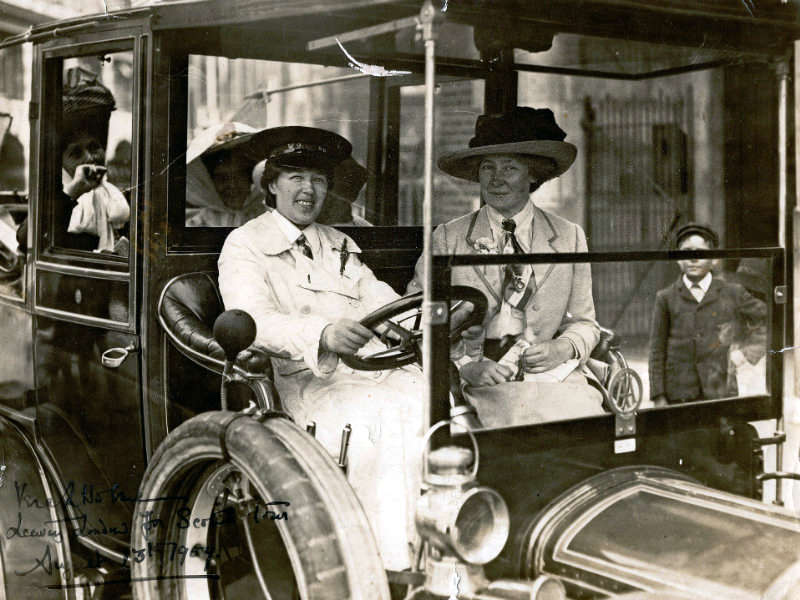 Vera 'Jack' Holme driving a car smiling