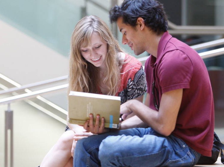 Two students looking at a book | Study at LSE