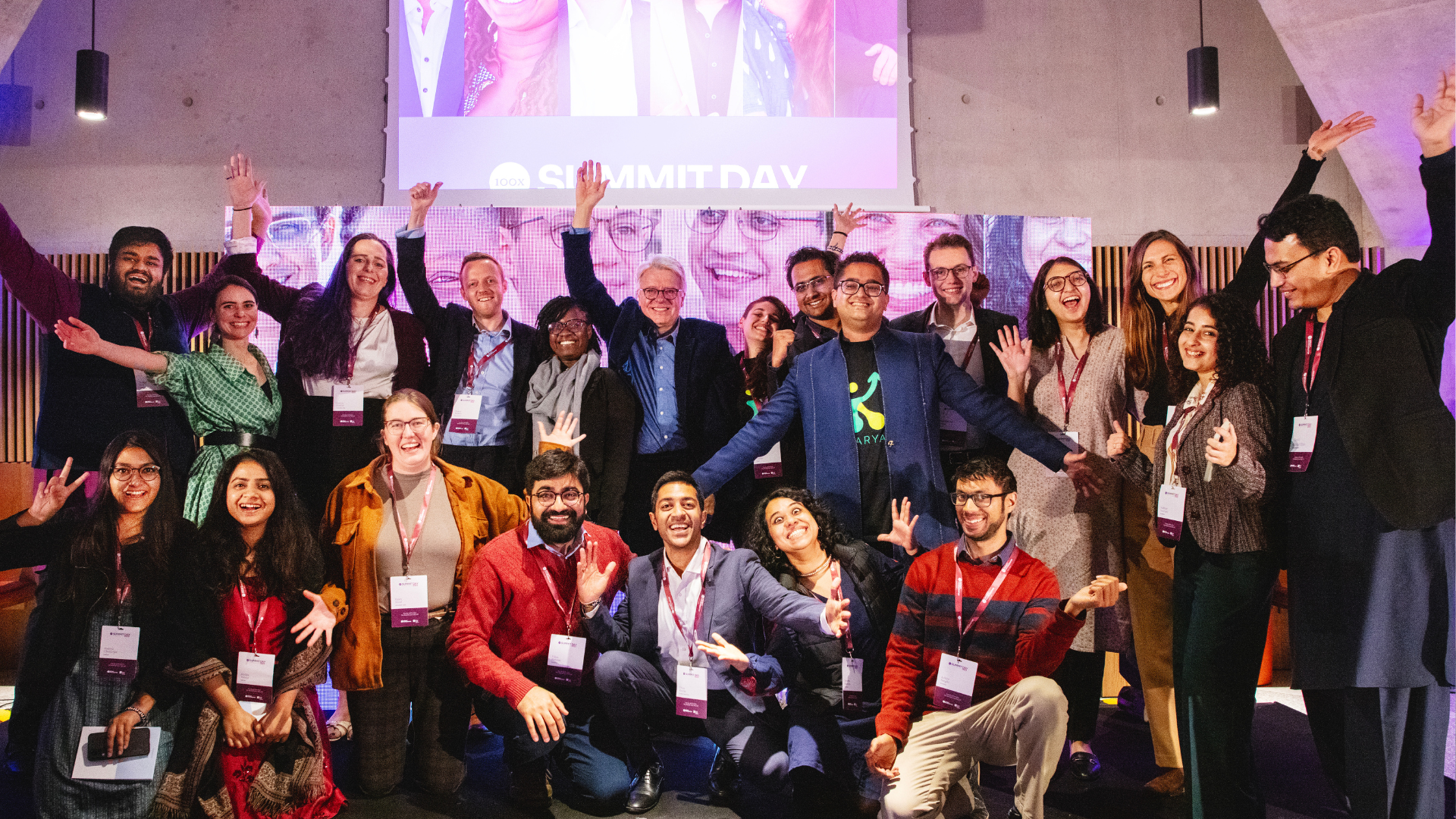 Group of cohort 1 celebrating with their arms outstretched.